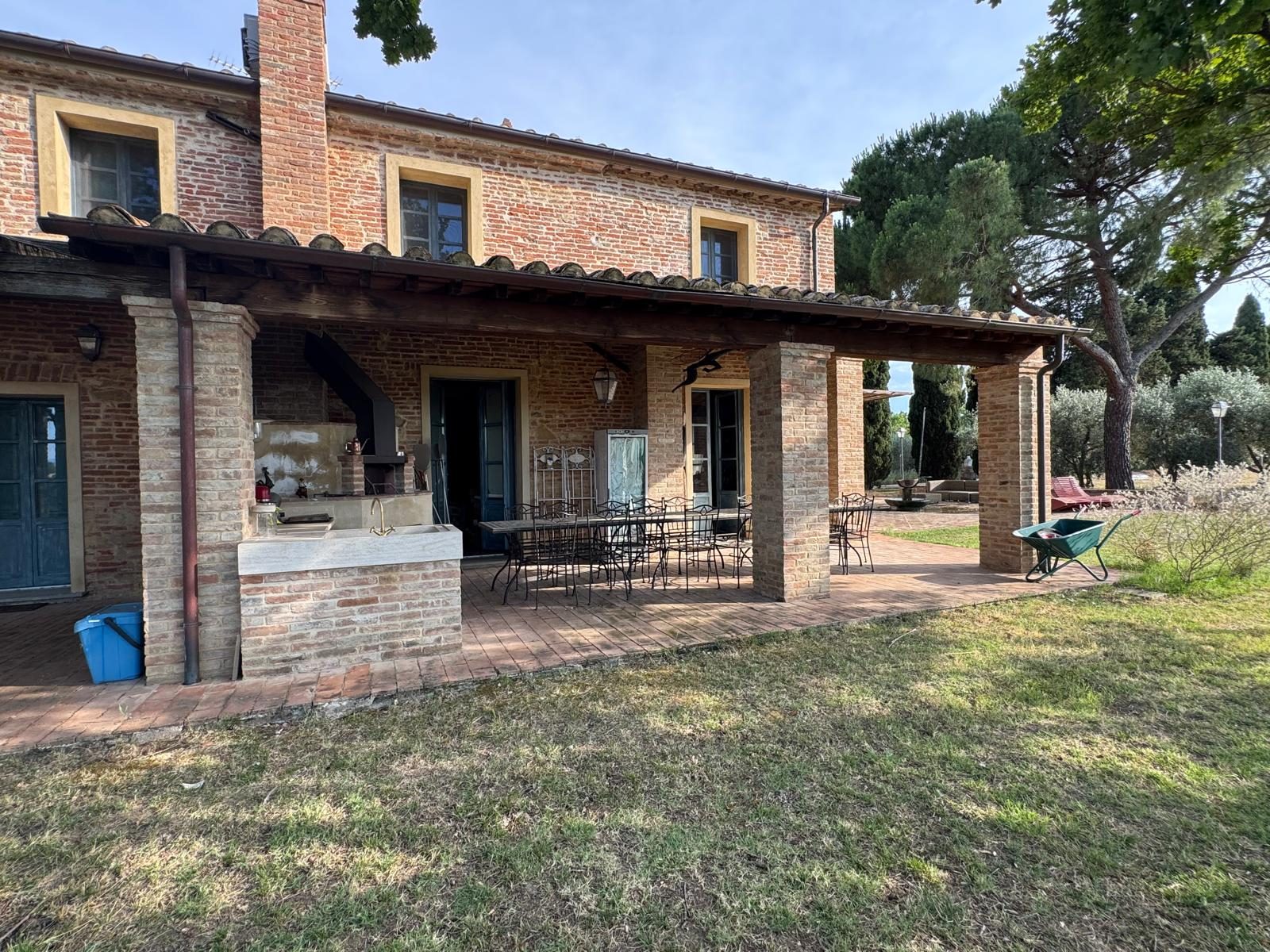 Il portico in mattoni del casale, affacciato sul prato